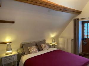 um quarto com uma cama com duas almofadas em Le Moulin de Pasnel em Monteaux