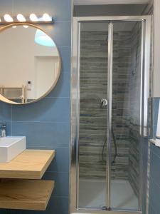 a bathroom with a shower with a sink and a mirror at Appartamenti Tina Paolini 1 piano terra con parcheggio in Castiglione della Pescaia +8 photos