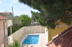 a swimming pool in front of a house at Apartments Villa-G Lustica in Tivat