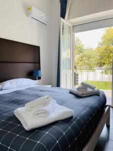 1 dormitorio con 1 cama con toallas en Banus Rooms en Cagliari