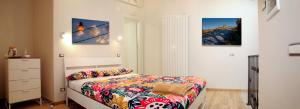 Nelle Stanze Del Matese في Boiano: غرفة نوم بسرير وصورتين على الحائط