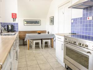 uma cozinha com uma mesa e uma parede de azulejos azuis em Kirklands Garden House em Melrose