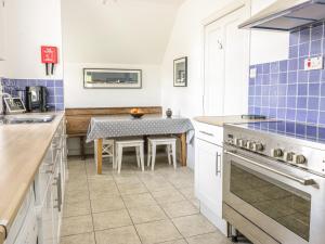 cocina con mesa y pared de azulejos azules en Kirklands Garden House en Melrose