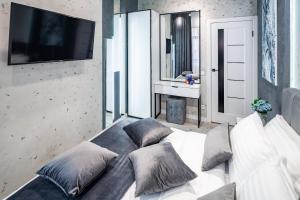 a living room with a white couch with pillows at Alfa Apartments Kulisha 12 in Lviv