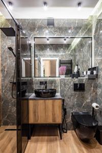 a bathroom with a black sink and a mirror at Alfa Apartments Kulisha 12 in Lviv