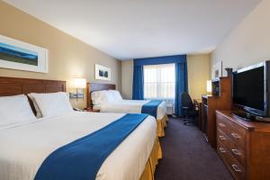 a hotel room with two beds and a flat screen tv at Holiday Inn Express Deer Lake, an IHG Hotel in Deer Lake