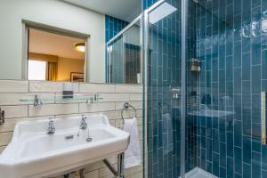 a bathroom with a sink and a glass shower at Riva Boutique Hotel in Helensburgh +61 photos