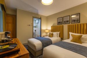 a hotel room with two beds and a table at Riva Boutique Hotel in Helensburgh +64 photos