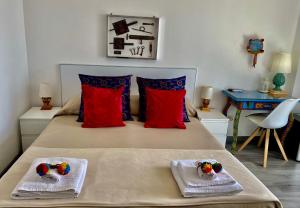 1 dormitorio con 1 cama con almohadas rojas y azules en Chiaro di Luna, en Taormina