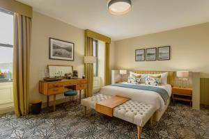 a hotel room with a bed and a desk and a mirror at Riva Boutique Hotel in Helensburgh