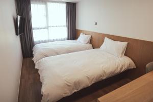 Voodi või voodid majutusasutuse Kenny Stay Jeju Mosulpo toas