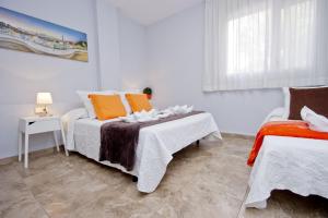 a bedroom with two beds with white and orange pillows at Barcelona City Seven in Barcelona