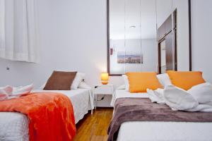 バルセロナにあるバルセロナ シティ セブンのオレンジと白のベッド2台が備わる客室です。