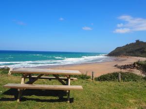 a wooden picnic table sitting on top of a beach at La Cristalina in Prado +14 photos
