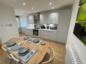 a kitchen with a wooden table with plates and wine glasses at Shepherd Moon in Talmine