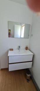 La salle de bains est pourvue d'un lavabo blanc et d'un miroir. dans l'établissement La Cabane de Fierville, à Fierville-les-Parcs
