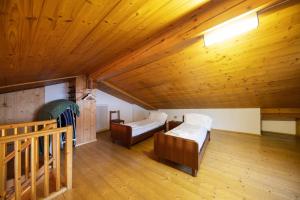 Cette chambre mansardée comprend deux lits et un plafond en bois. dans l'établissement Mandarda stile rustico 6/8 letti, à Predazzo