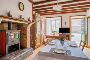 een eetkamer met een tafel en een open haard bij Gîte de la Forge in Millières