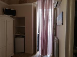 a room with a window with a pink curtain at Al Rosa Antico in Monopoli