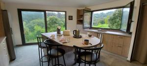 a kitchen with a table with four chairs and large windows at Corse et Zen LOFT ZEN 145m2 8à9 pers in Taglio-Isolaccio +16 photos