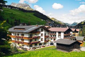 un grand bâtiment au milieu d'une montagne dans l'établissement Hotel Garni Lavendel, à Lech am Arlberg