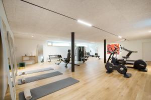 a gym with several treadmills and exercise bikes in it at Hotel Schwärzler in Bregenz