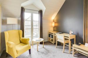 een woonkamer met een gele stoel en een bureau bij Château De Villiers-Le-Mahieu in Villiers-le-Mahieu