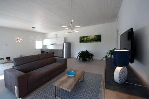 ein Wohnzimmer mit einem braunen Sofa und einem Tisch in der Unterkunft Residence Le Querce in Cordovado