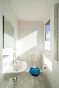 a bathroom with a white sink and a blue stool at Ferienwohnung 3, Waldesruh Dierhagen in Dierhagen