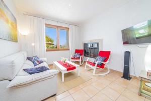 a living room with a couch and two red chairs at E227 Sa Pedrera by Mallorca Villa Selection in Caʼs Concos