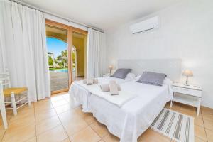 a white bedroom with a large bed and a window at E227 Sa Pedrera by Mallorca Villa Selection in Caʼs Concos +45 photos