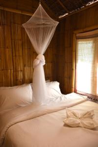 Ban RaiにあるBan Rai Jai Chaem - Spa Cafe & Homestayのベッドルーム(蚊帳付きのベッド付)