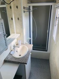 La salle de bains est pourvue d'un lavabo et d'une douche. dans l'établissement Mobil-home 4 personnes 400m de la mer, à Berck-sur-Mer