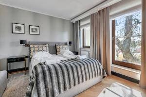 a bedroom with a large bed and a window at Premium Apartment with Sauna by Grand Apartments in Sopot
