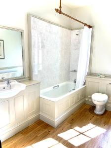 a bathroom with a tub and a toilet and a sink at The Sportsman's Arms in Harrogate