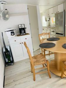 une cuisine avec une table et des chaises ainsi qu'une salle à manger dans l'établissement Mobil-home 4 personnes 400m de la mer, à Berck-sur-Mer