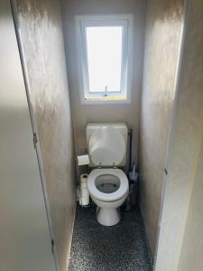 a small bathroom with a toilet with a window at Mobil-home 4 personnes 400m de la mer in Berck-sur-Mer