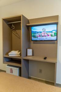 a room with a flat screen tv on a wall at Pousada Show Park in Penha