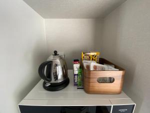 a shelf with a tea kettle and a box on it at BATONWORKS Naoshima in Naoshima