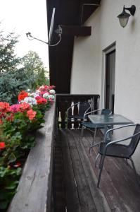 eine Terrasse mit 2 Stühlen, einem Tisch und Blumen in der Unterkunft Ferienwohnung "Lindenblick" in Gablenz
