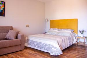 - une chambre avec un lit et un canapé dans l'établissement Apartamentos Luarca, à Luarca