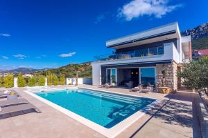 een villa met een zwembad en een huis bij Luxurius Villa Aria with heated 45sqm pool, jacuzzi and seaview in Kaštela