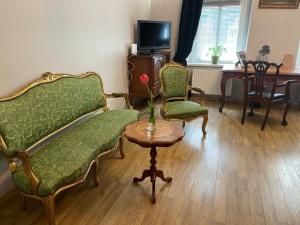 uma sala de estar com um sofá e duas cadeiras e uma mesa em APARTMENT SILESIAN STADIUM and PARK em Chorzów