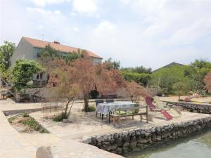 patio ze stołem i krzesłami nad wodą w obiekcie Kornati - Apartments & Stone cottage w mieście Kornati