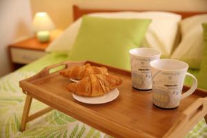 2 croissants et 2 tasses sur une table en bois dans l'établissement Apartments Villa Mareta, à Sukošan