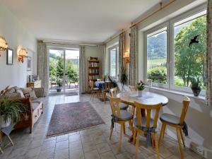salon ze stołem, krzesłami i oknami w obiekcie Rosenhof am See Ferienwohnung Alpenrose w mieście Thiersee