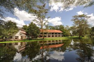 a house next to a lake with trees at Hunters Lodge in Twaandu