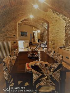 sala de estar con mesa de madera y pared de piedra en "Il Pollaio" guests house, en Panicale