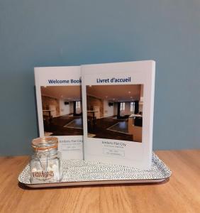 two books on a table with a candle and a glass jar at Cordeliers Jordans Flat City centre historique in Dijon