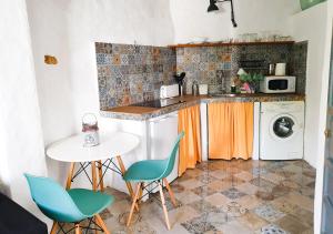a kitchen with a table and a washing machine at Ojalá... in Vejer de la Frontera